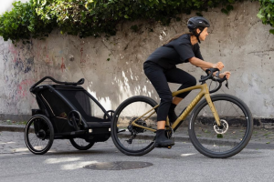 dame sur un vélo avec une remorque vélo à l'arrière
