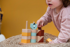 petite fille qui empile des petits blocs en bois