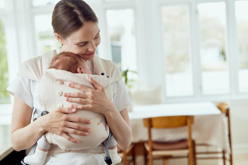 Maman tenant bébé dans porte-bébé