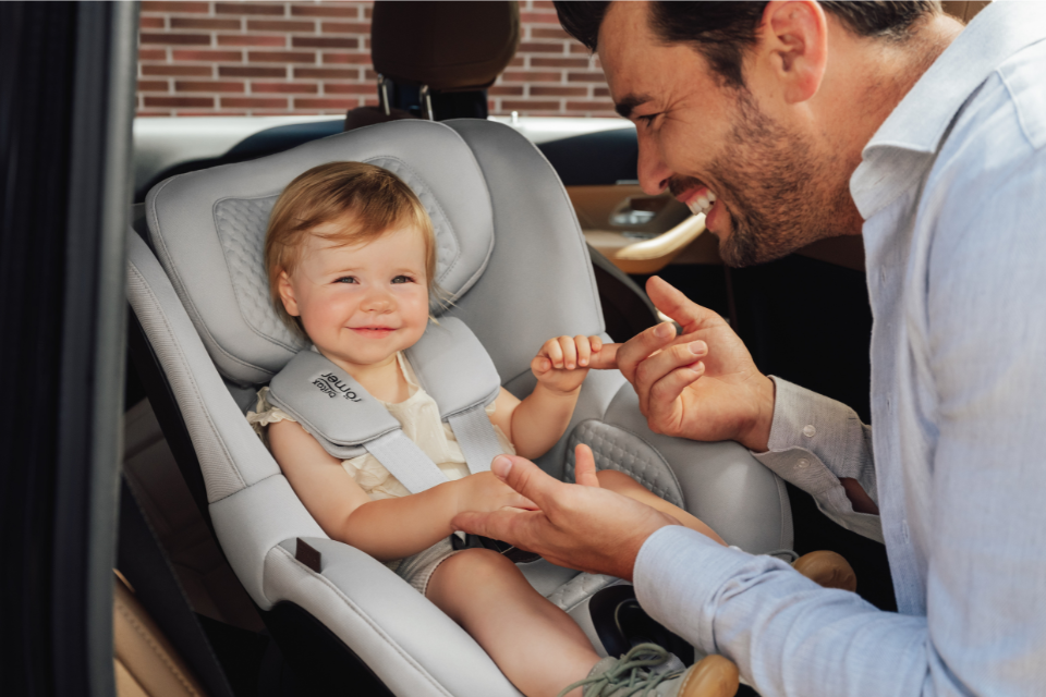bébé dans siège-auto qui tient le doigt de papa