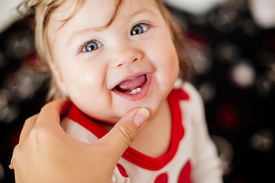 petite fille qui montre ses deux dents avant