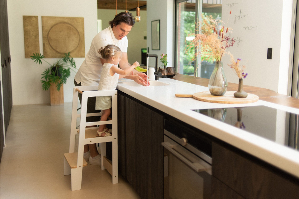 petite fille sur tour d'apprentissage avec papa à côté d'elle