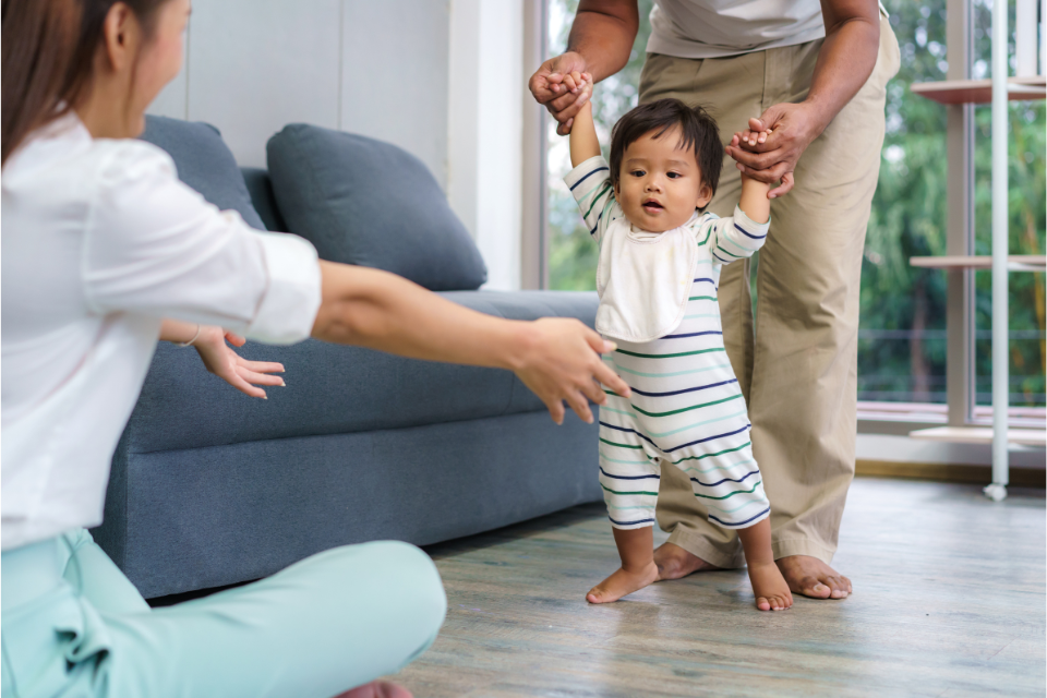 bébé qui apprend à marcher avec ses parents