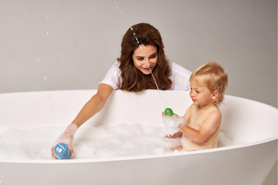 bébé dans bain avec maman à côté
