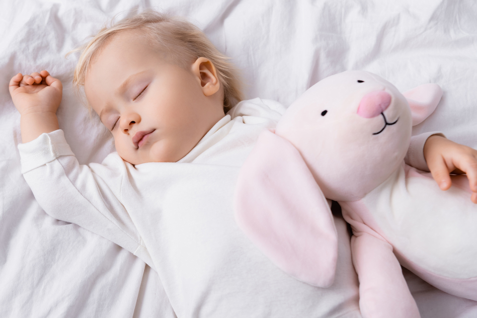 fille qui dort avec une peluche rose